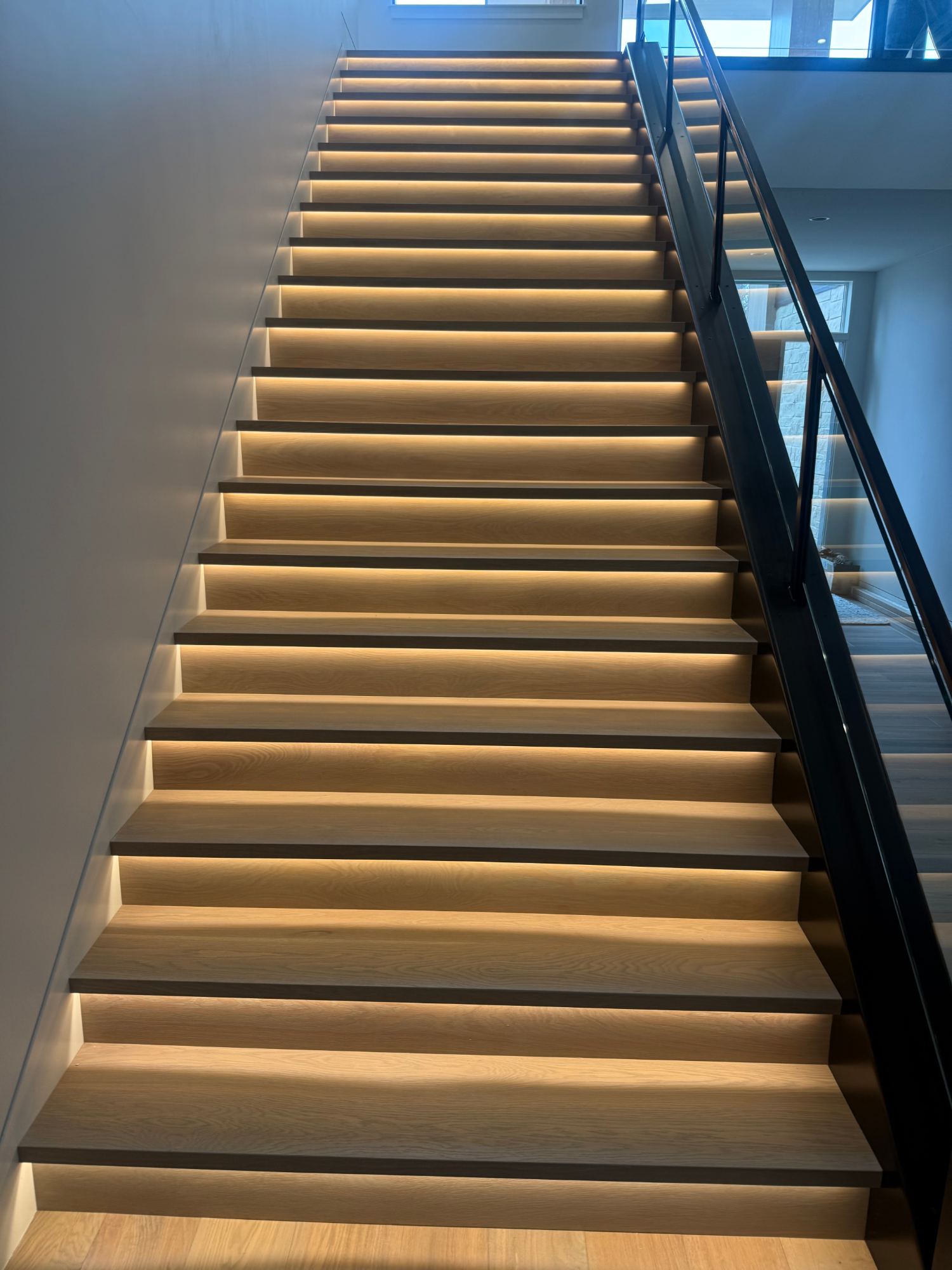 Open-tread staircase remodel with hidden LED riser lighting installed by MG Electric